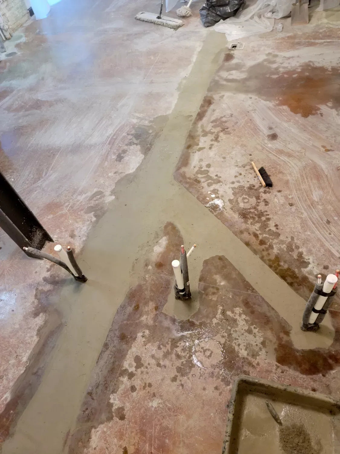 A concrete floor with a lot of concrete being poured on it.