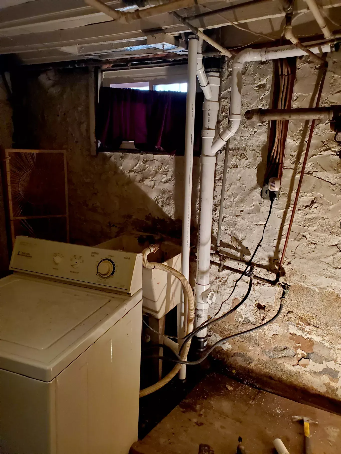 A washer and dryer are sitting in a basement.