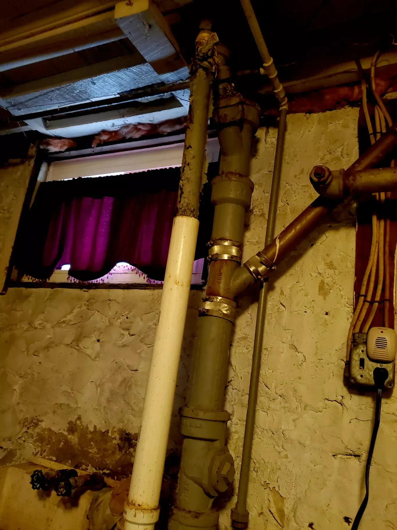A bunch of pipes are hanging from a wall in a room