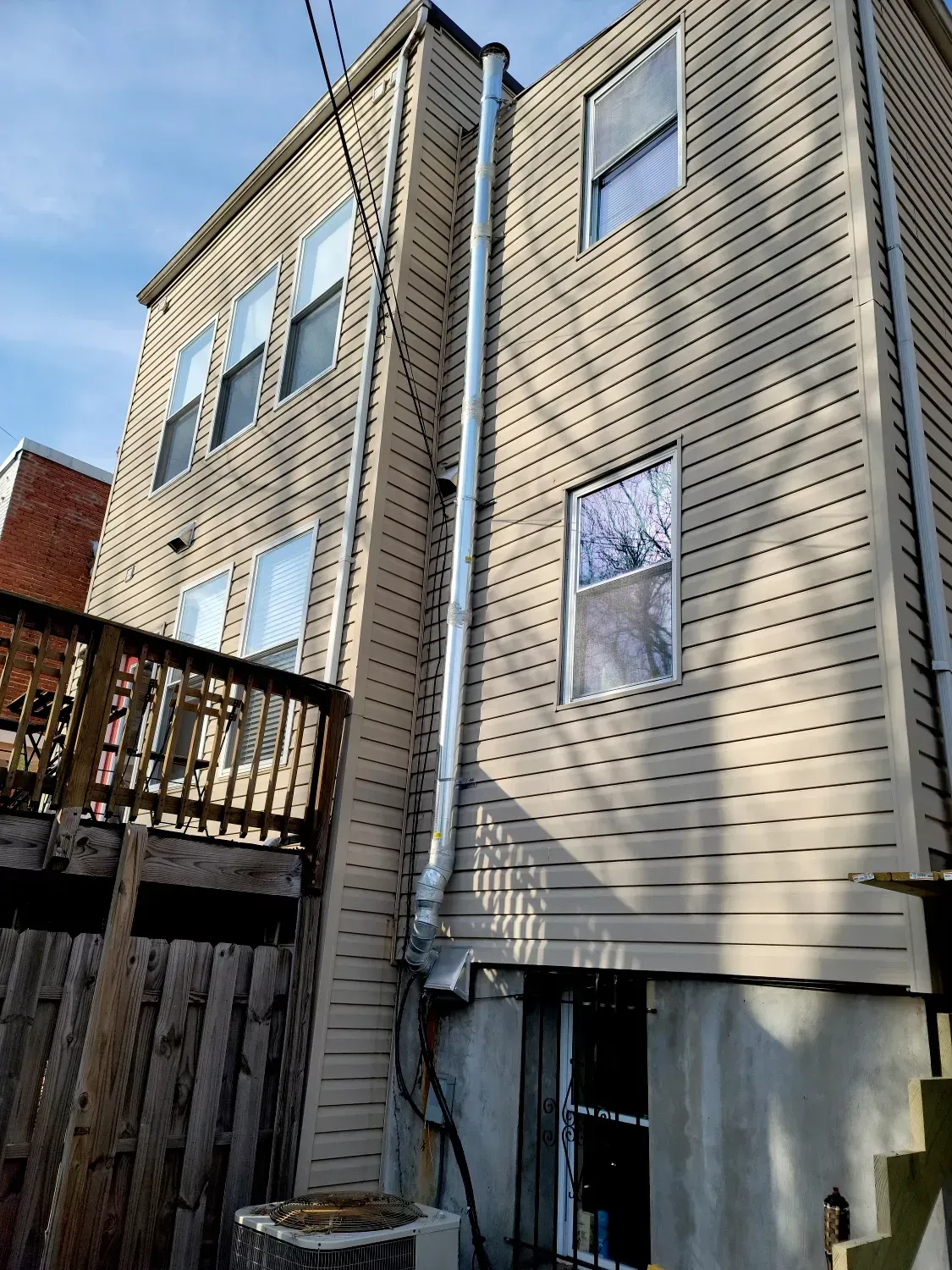 A large house with a lot of windows and a chimney on the side of it.