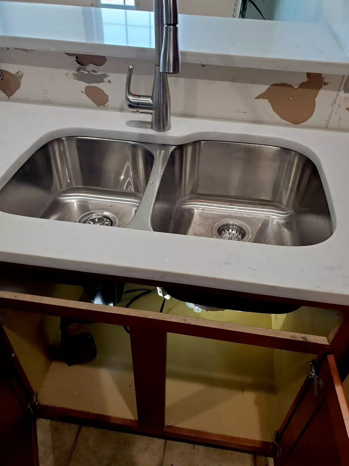 A kitchen sink with two stainless steel sinks and a faucet.