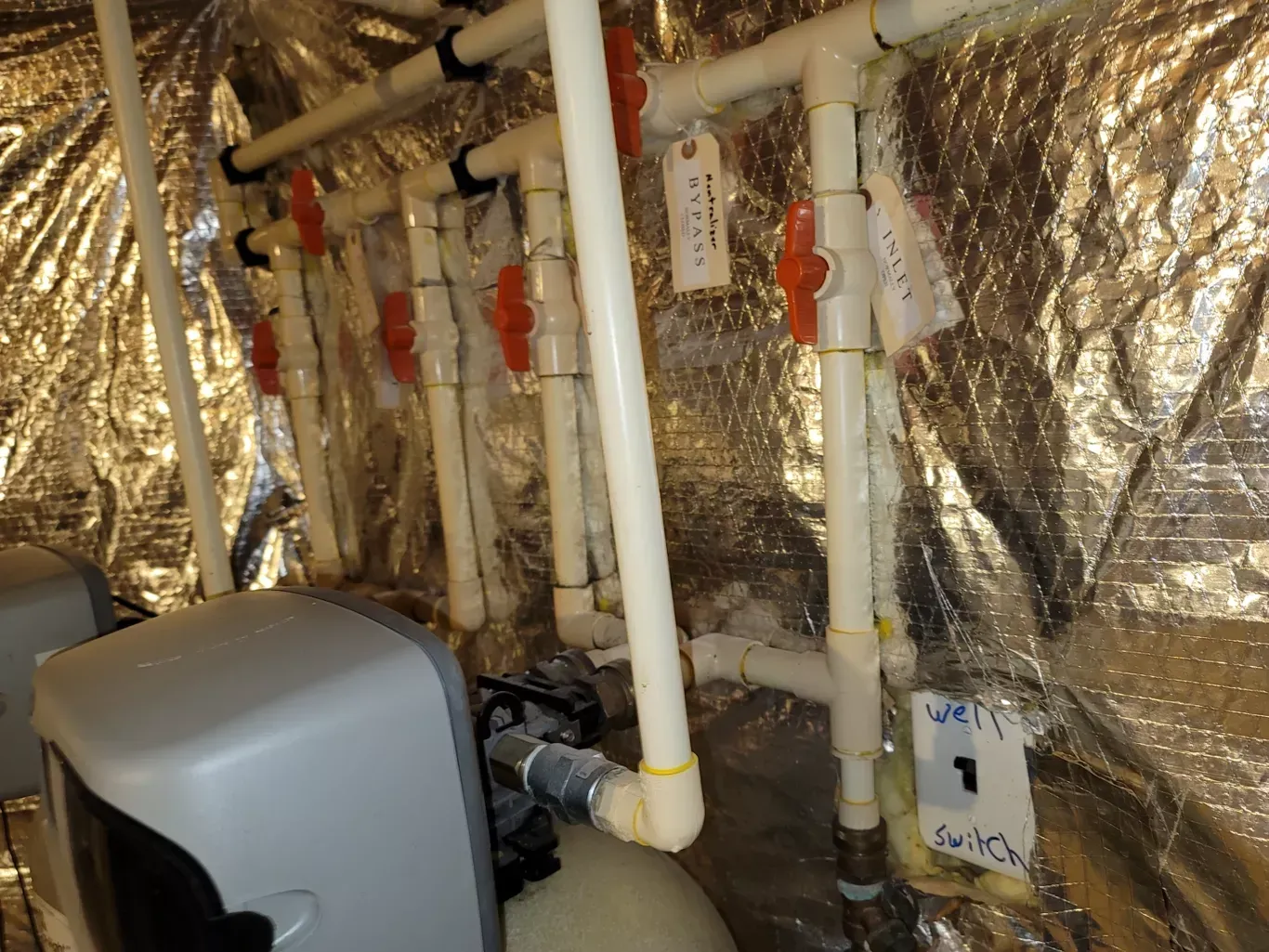 A room with a lot of pipes and a sign that says switch