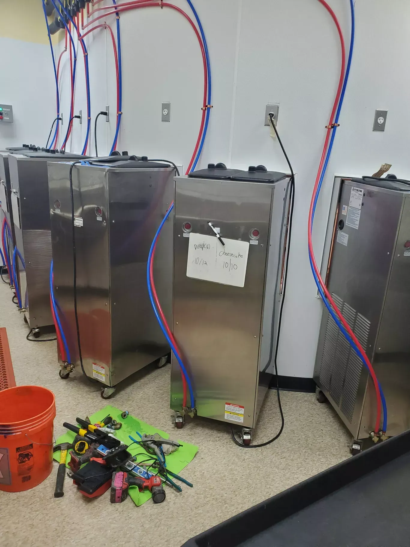 A row of stainless steel appliances are lined up in a room.