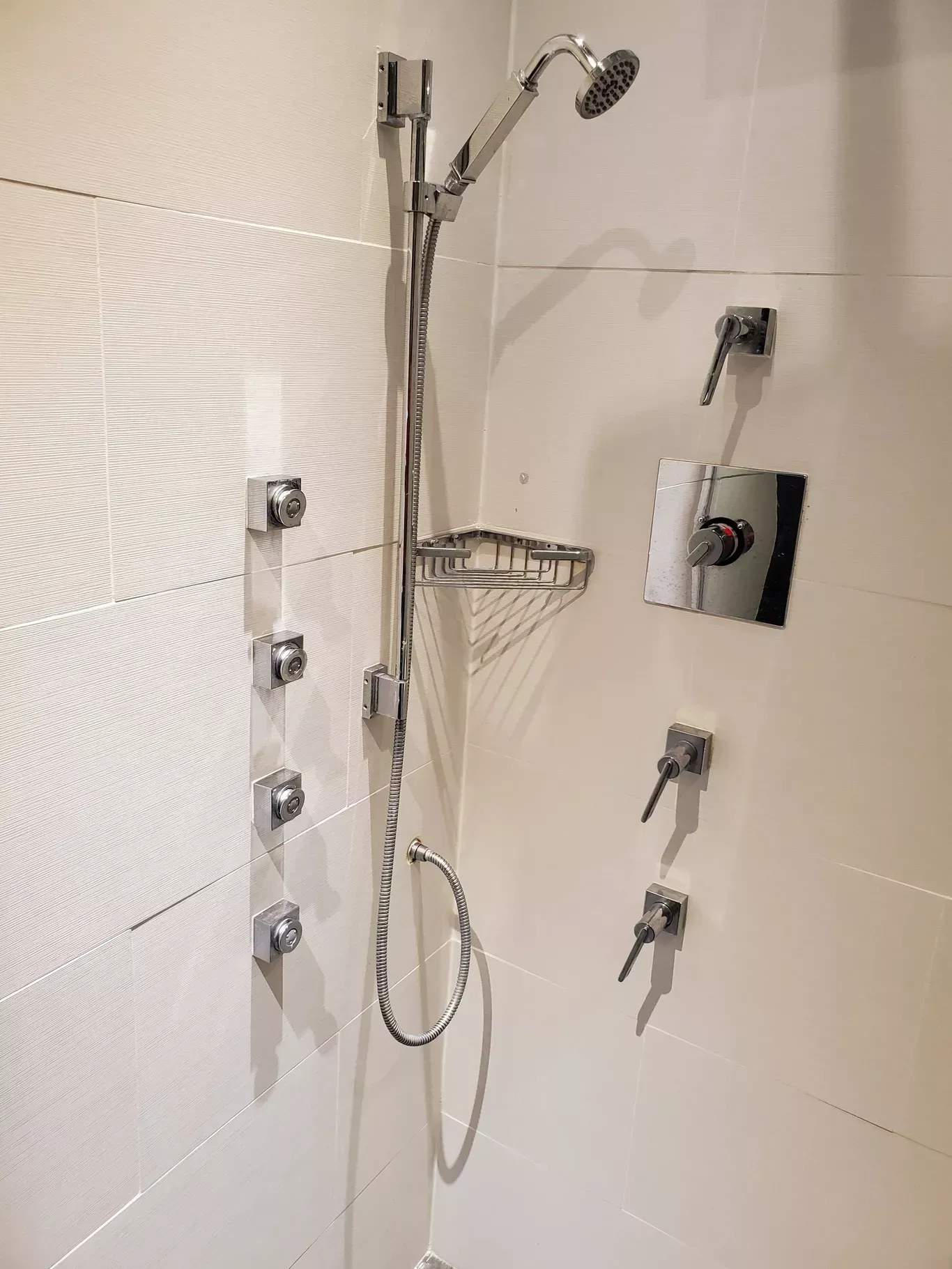 A shower head with a hose attached to it in a bathroom.