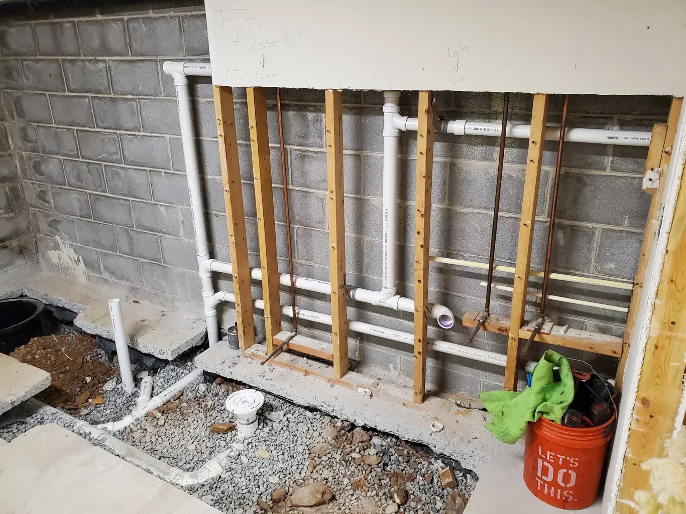 A basement with pipes and a bucket that says `` let 's do this ''.