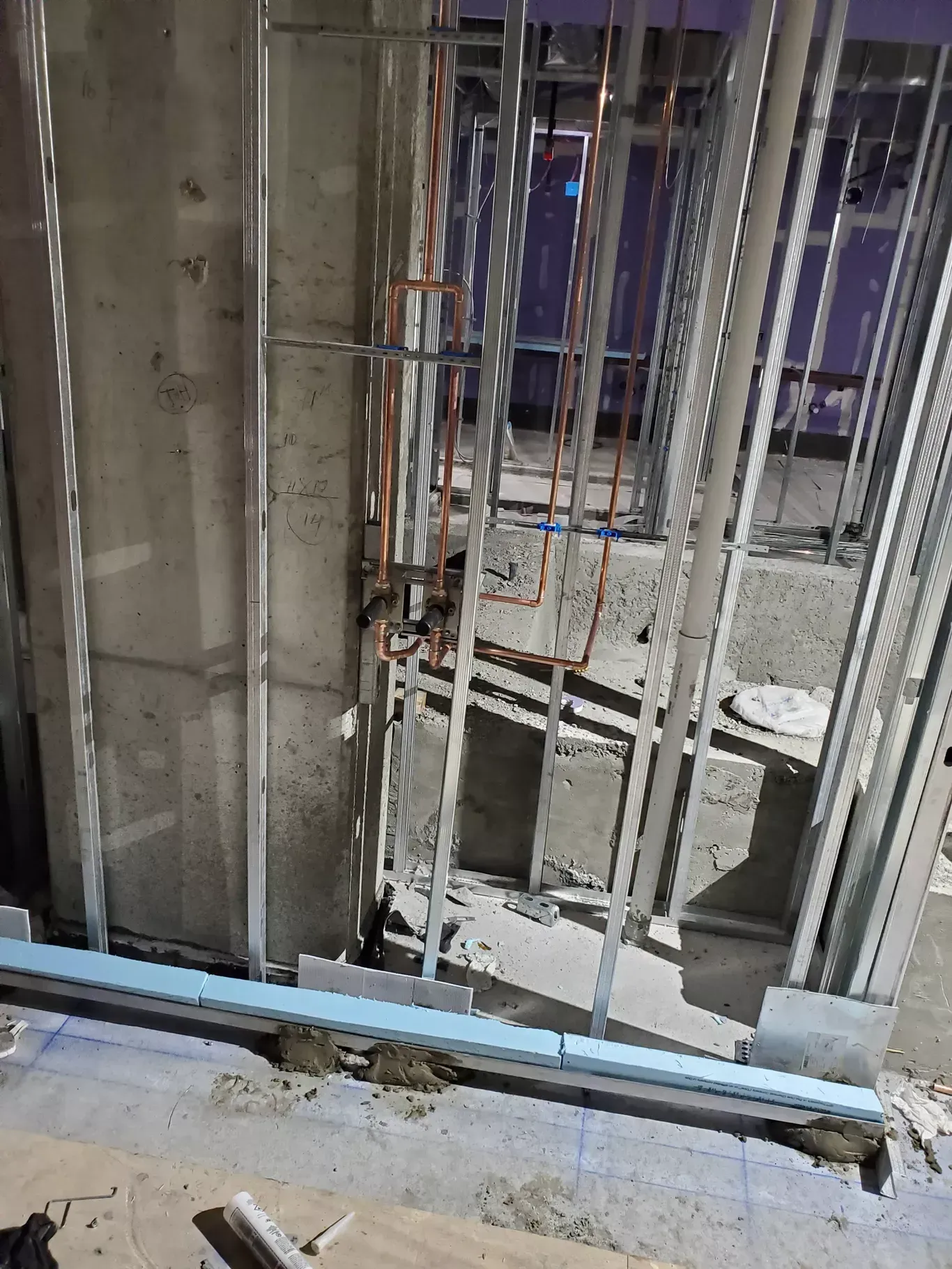 A building under construction with a ladder in the middle of the room.