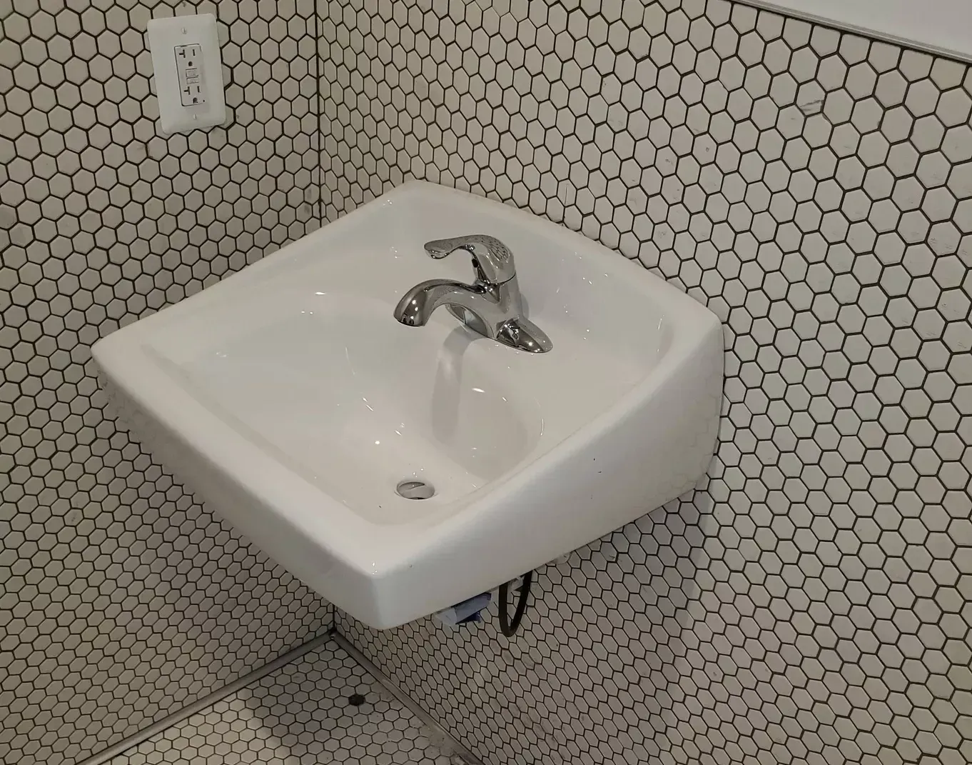 A white sink with a chrome faucet in a bathroom.