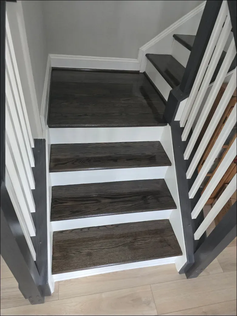 A staircase with wooden steps and a white railing.