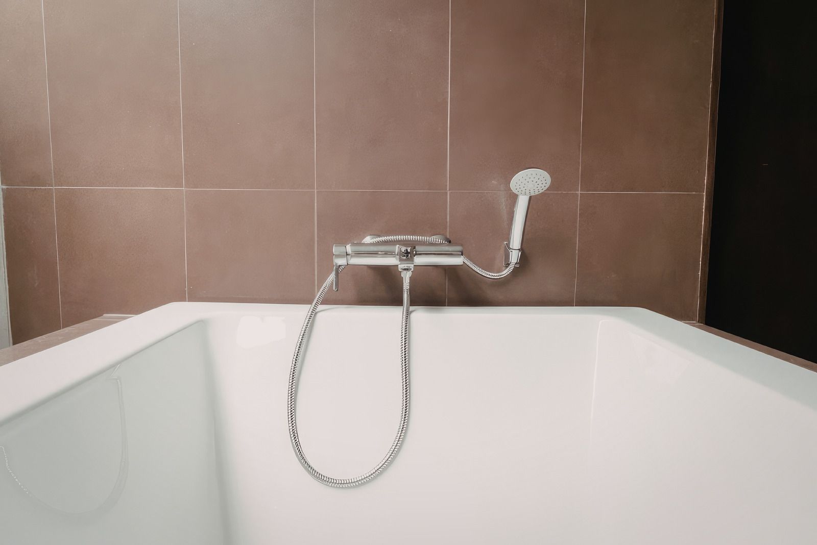 A sink with a drain pipe and a copper pipe underneath it.
