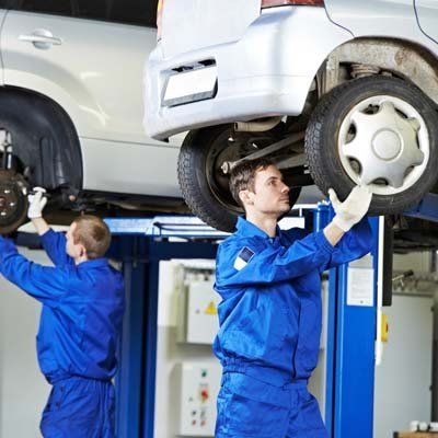 Two repair man installing car wheel - Walt's Auto Service Center, Taunton, MA