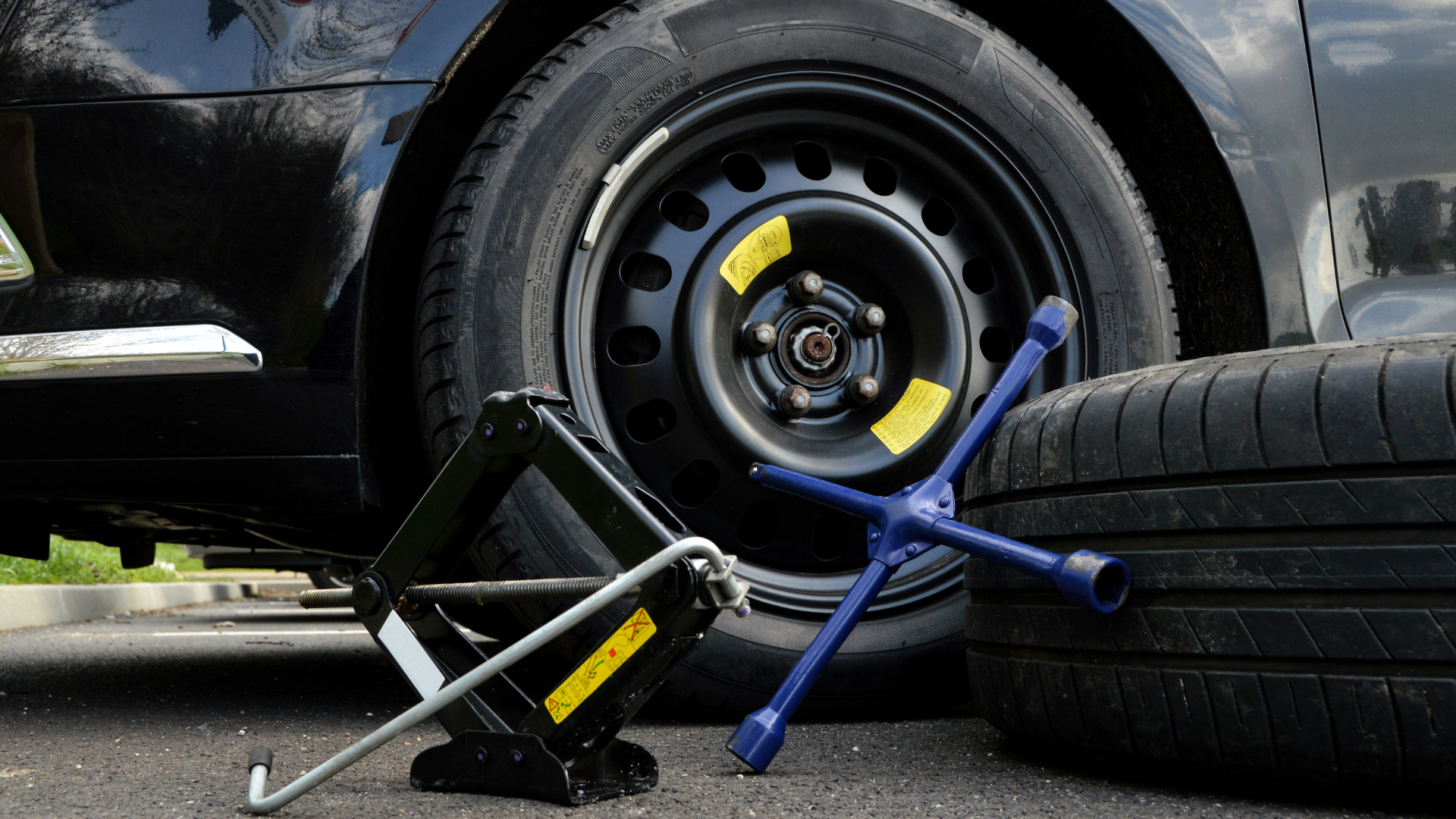 A car with a flat tire and a jack.
