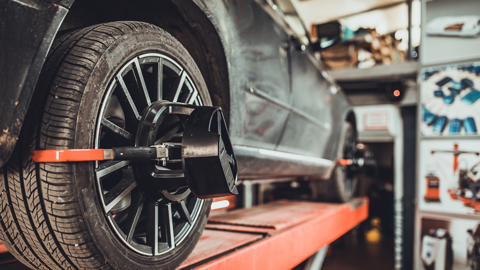 A car is being adjusted by a machine in a garage.