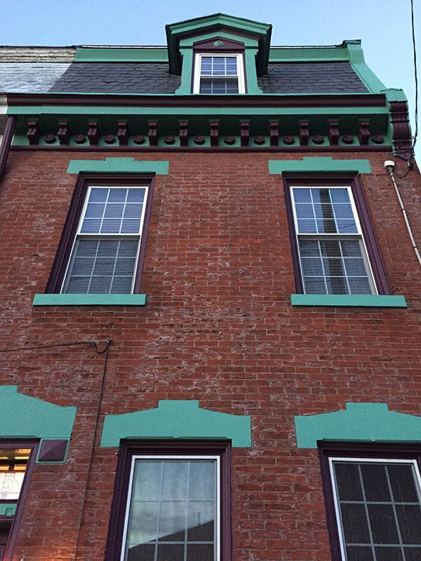 outside of building painted aqua on the stone work of the window and door sils