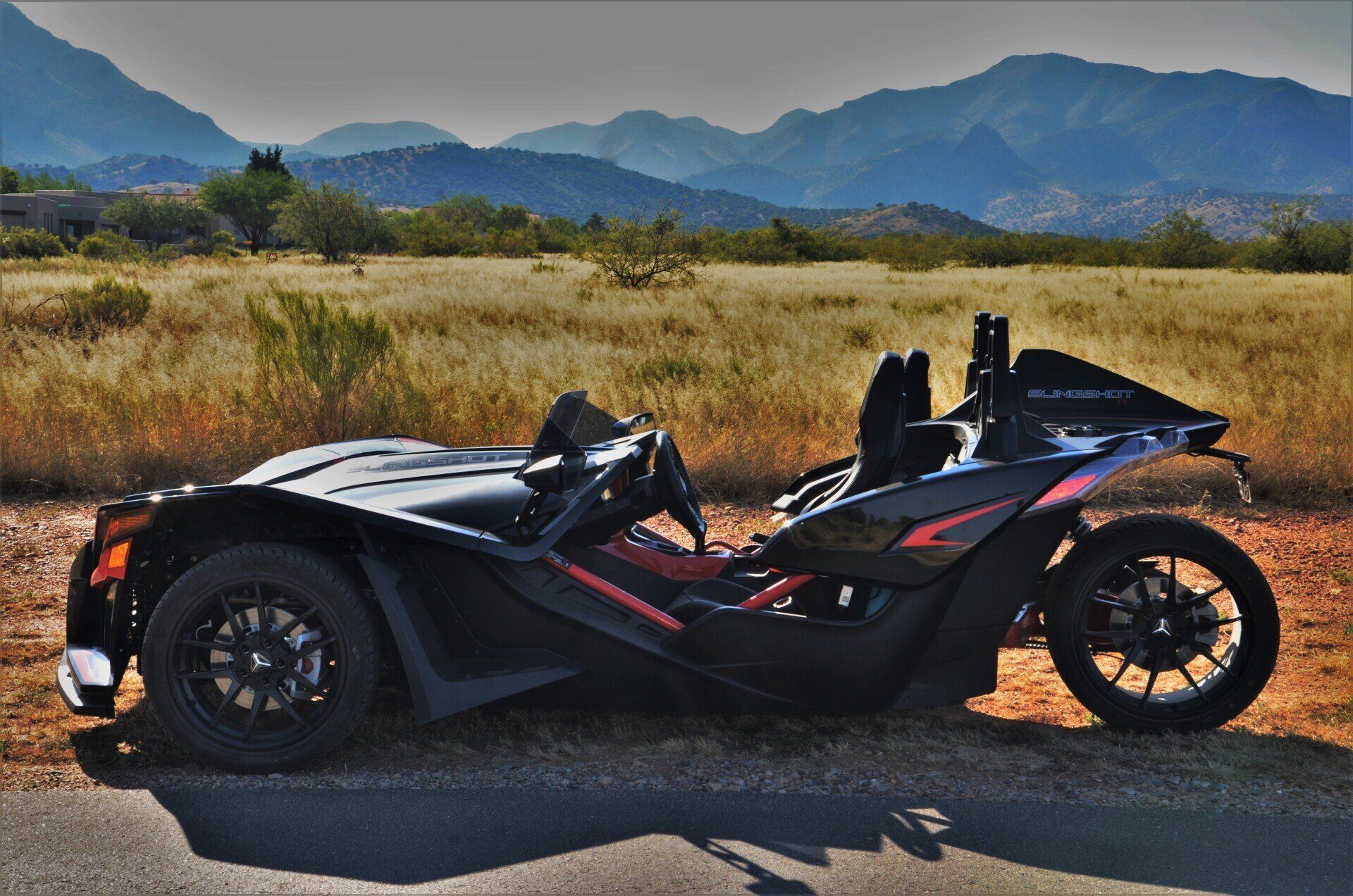 Black Polaris Slingshot on scenic road