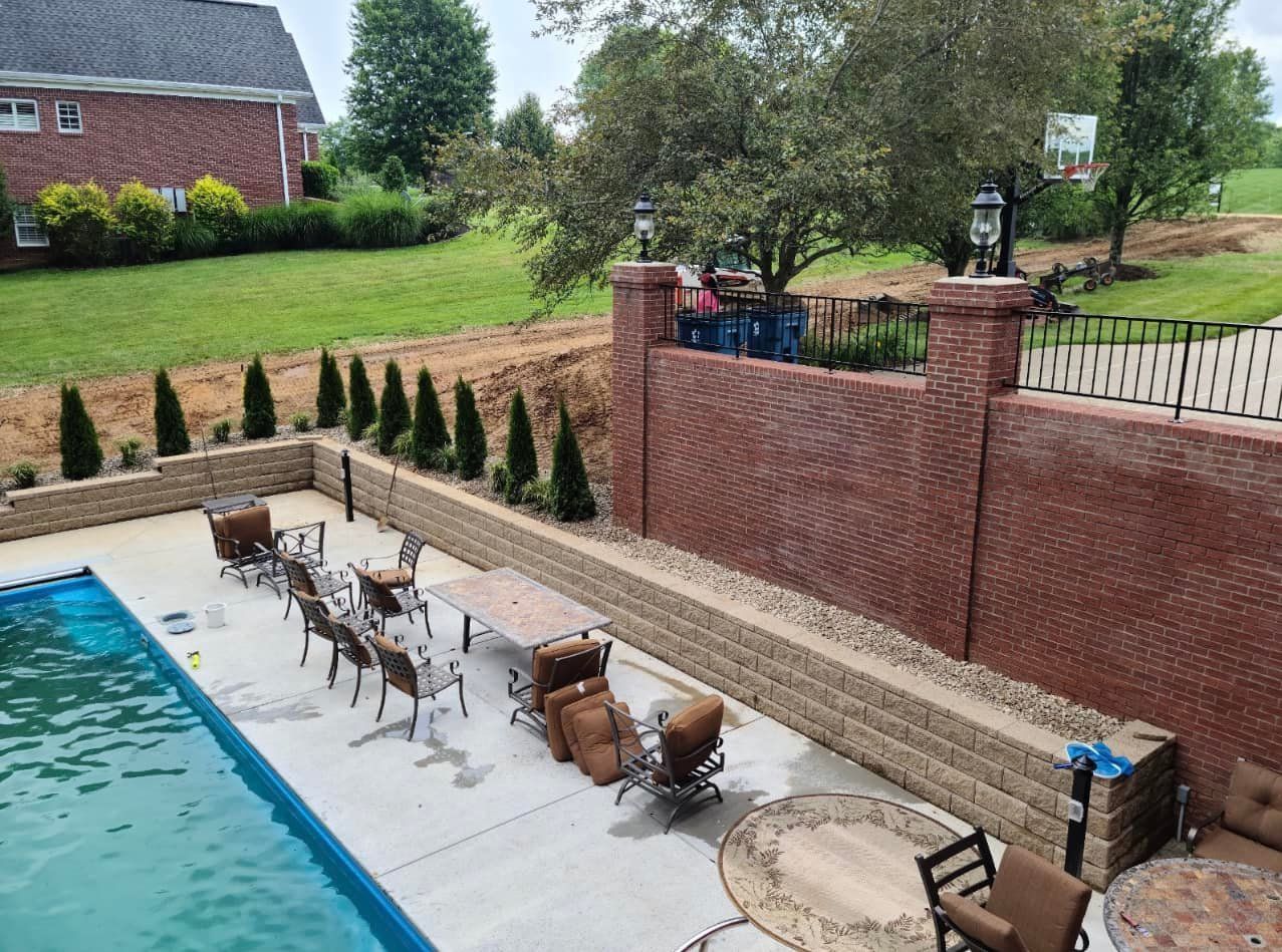 An aerial view of a backyard with a swimming pool and patio furniture.