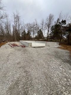 A large concrete structure is being built in the middle of a gravel road.