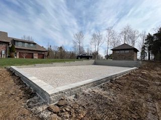 A concrete foundation is being built in front of a house.