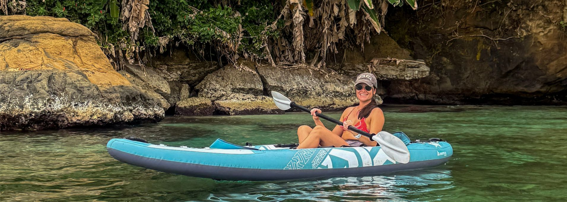 Kayaking in clear Caribbean water at Punta Uva, Costa Rica with jungle cliffs and tropical vegetation