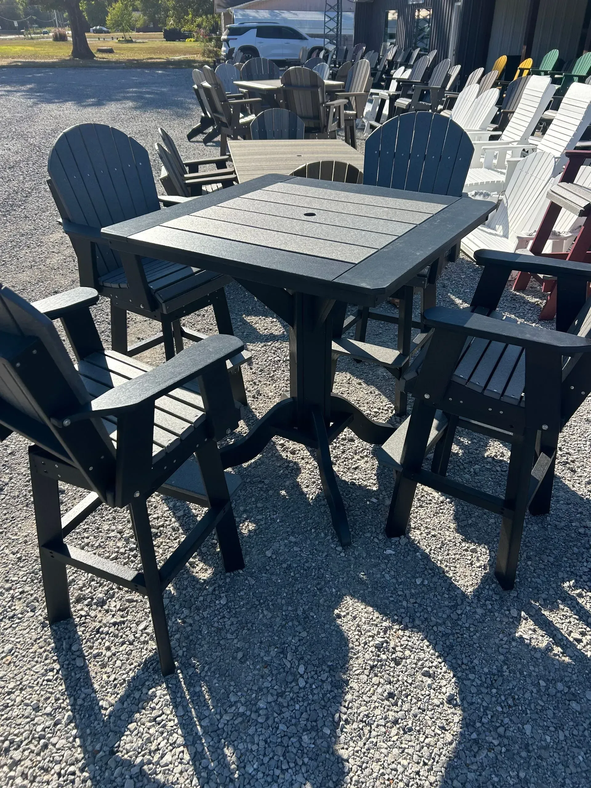 Outdoor patio set with a black square table and four matching chairs.