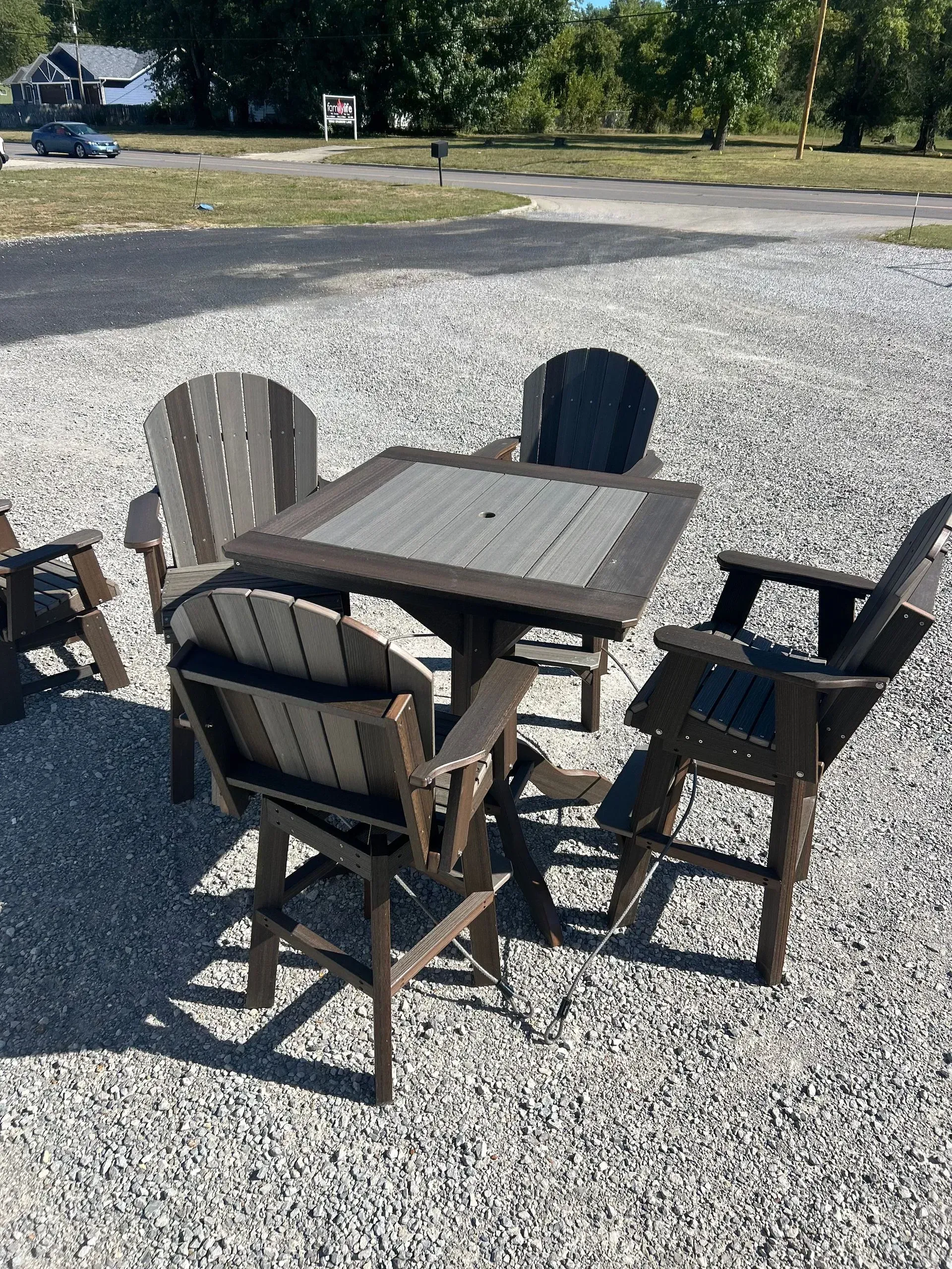 Outdoor table and chairs set on gravel. Brown and gray.