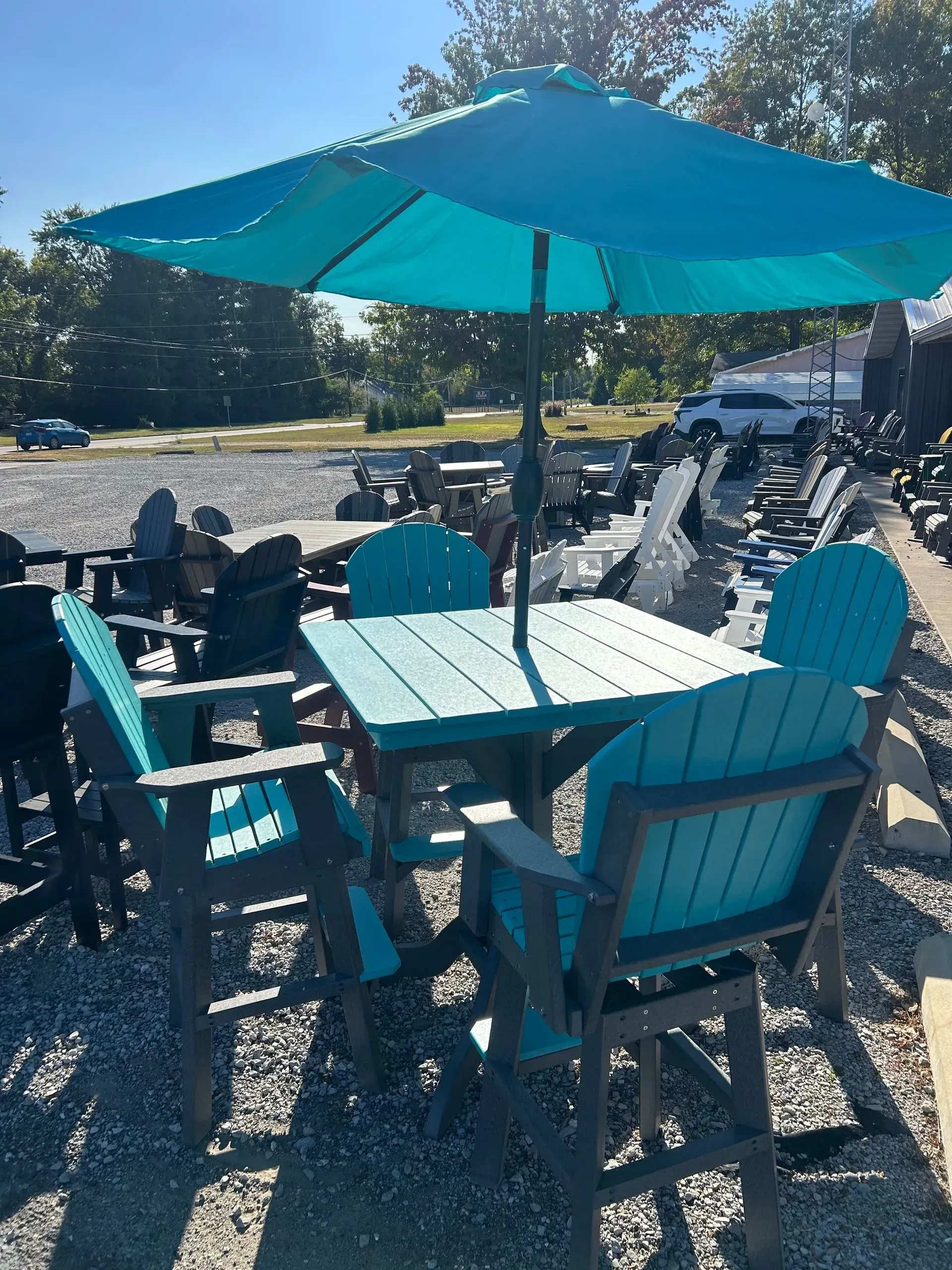 Outdoor teal patio set with umbrella, table, and chairs.