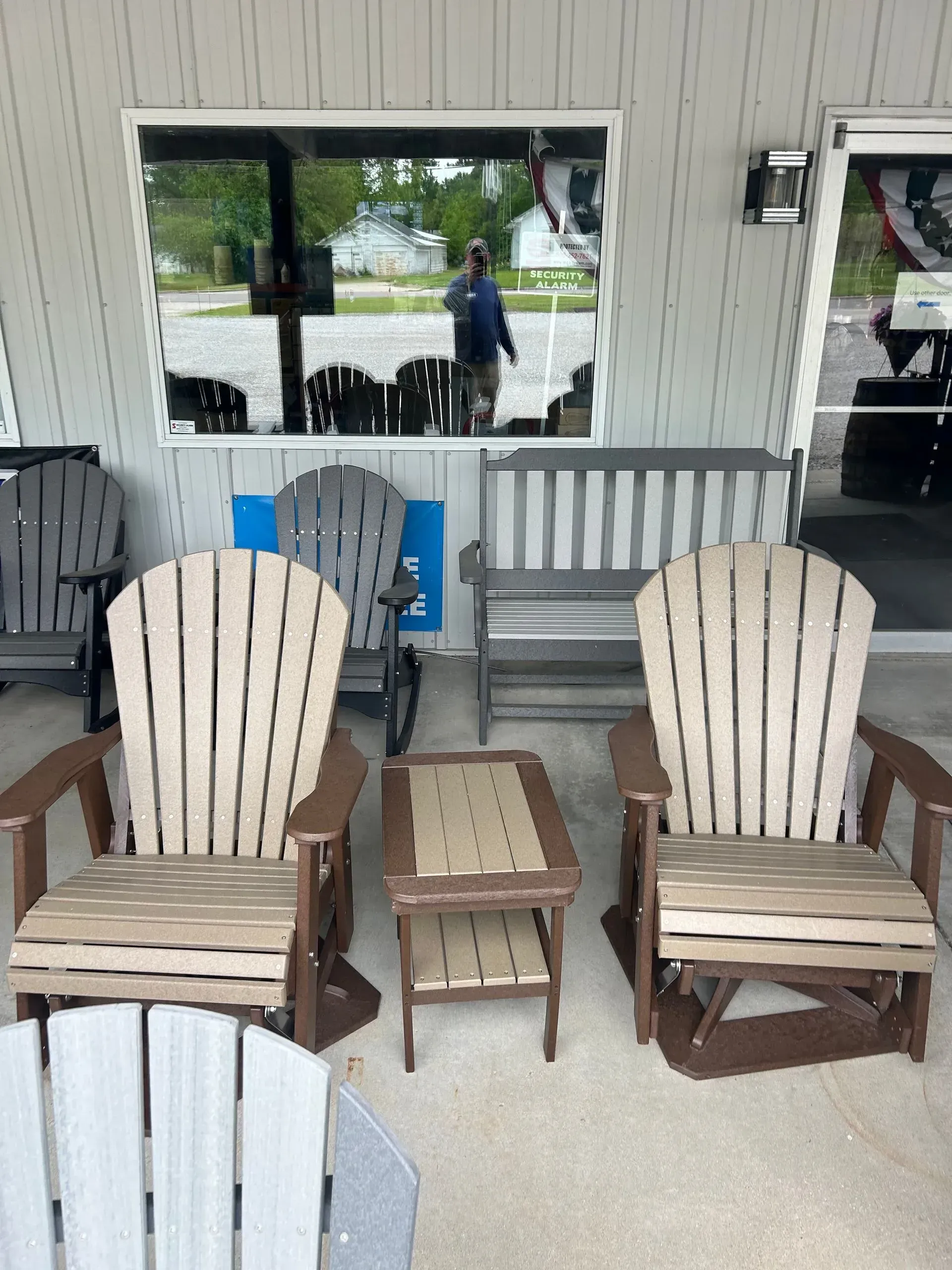 Outdoor furniture display: two beige and brown Adirondack chairs with a matching side table.