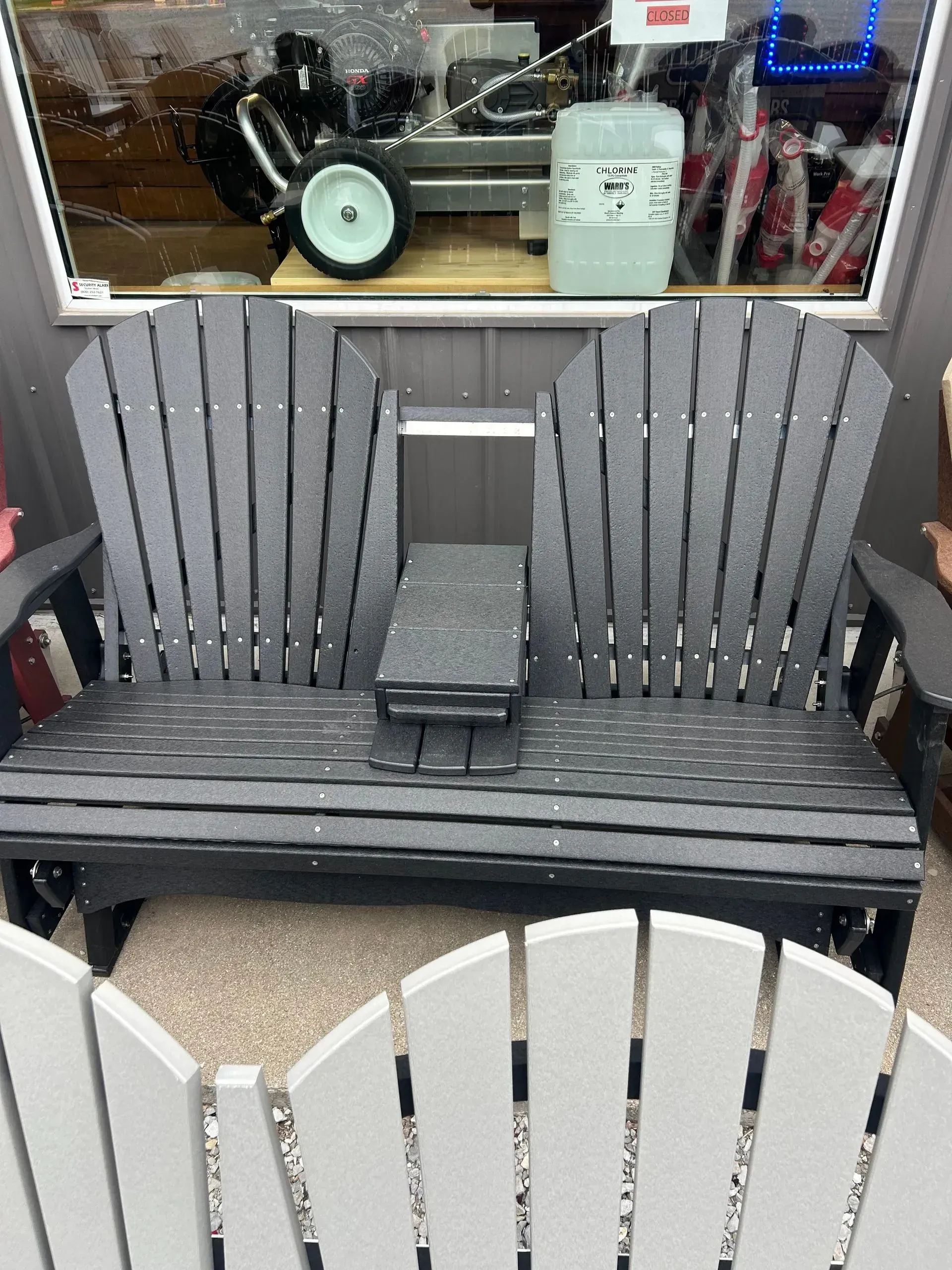 Gray double glider bench with center console, indoors.