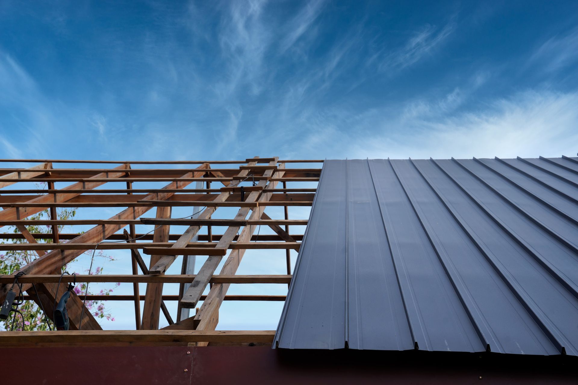 A metal roof is being installed on a house under construction.