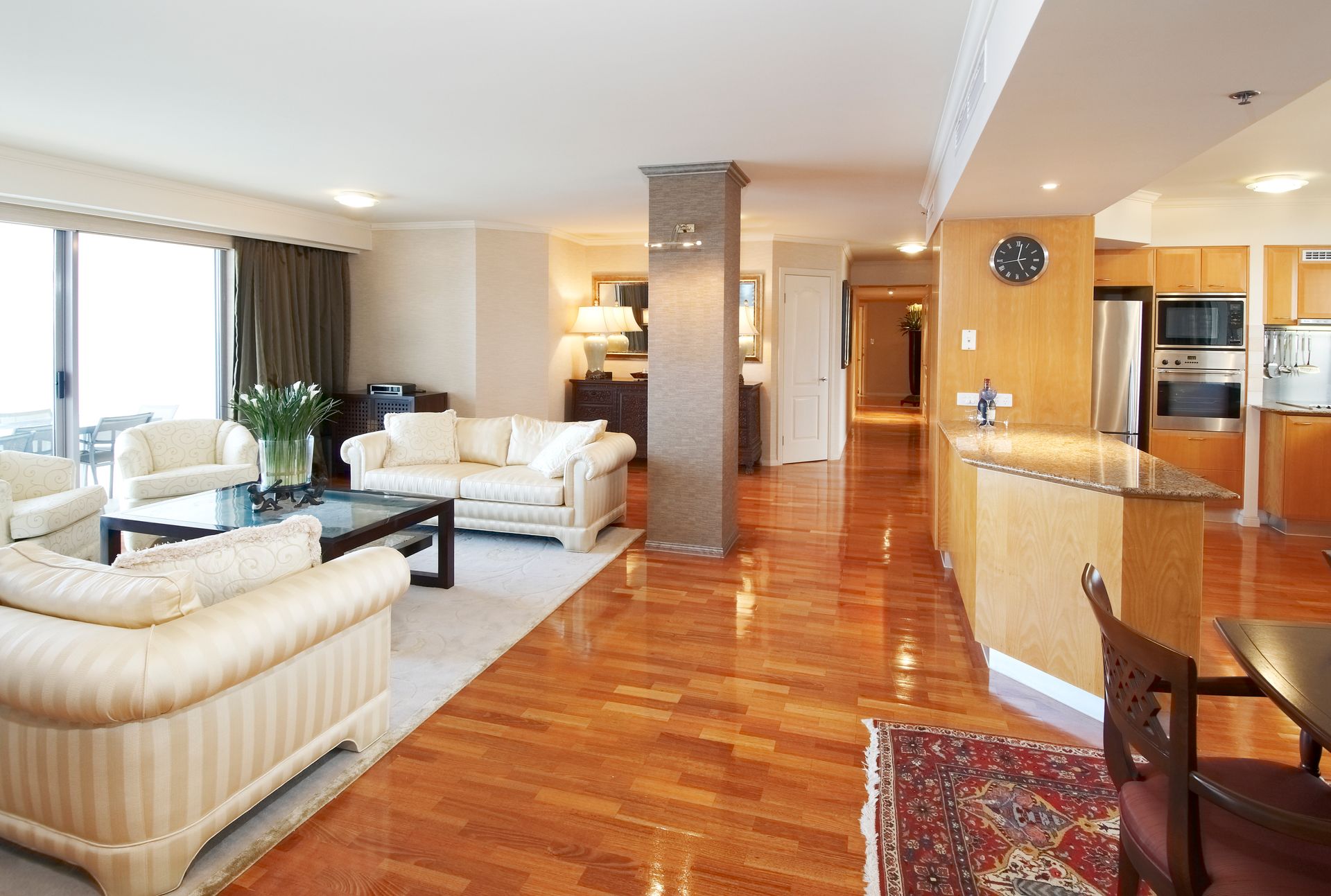 A living room with hardwood floors and a clock on the wall