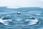 A drop of water is falling into a pool of water