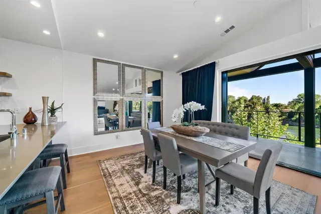 A dining room with a table and chairs and a large window.