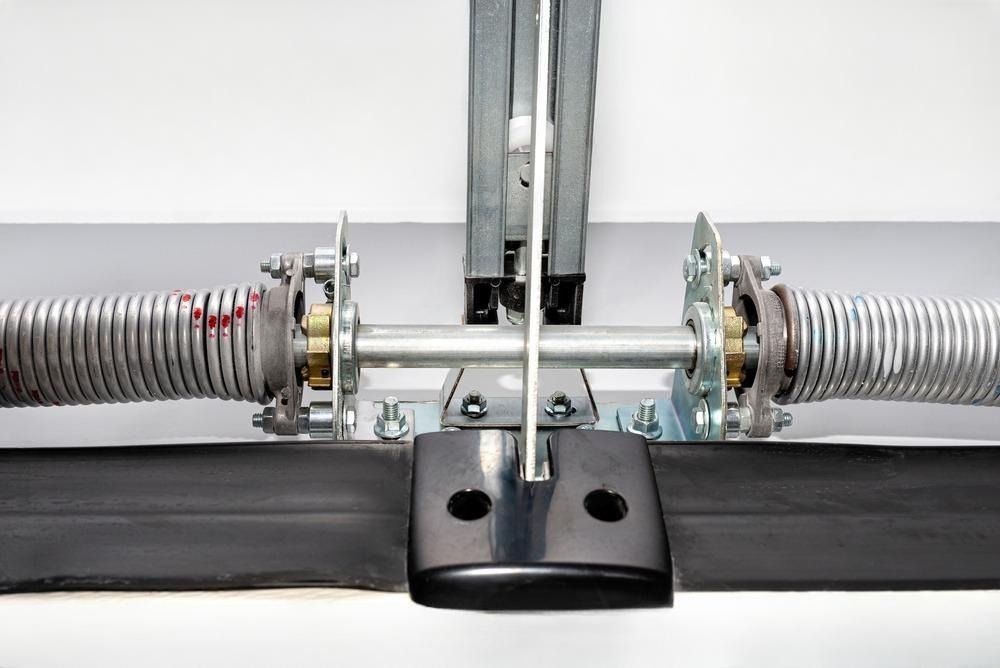 A close up of a garage door spring on a white background.