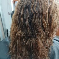 Wet, wavy brown hair with varying tones, seen from the back.