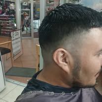 Man with a faded haircut, looking to the side. He is inside.