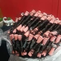 Dark hair wrapped around pink perm rods.