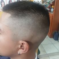 Close-up of a person's head with a high and tight fade haircut.