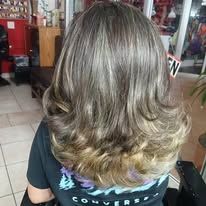 Woman's hair, a mix of blonde and brown shades, styled in voluminous curls.
