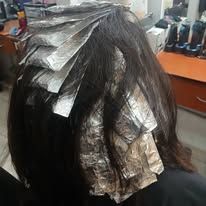 Hair with foil highlights being processed at a salon.