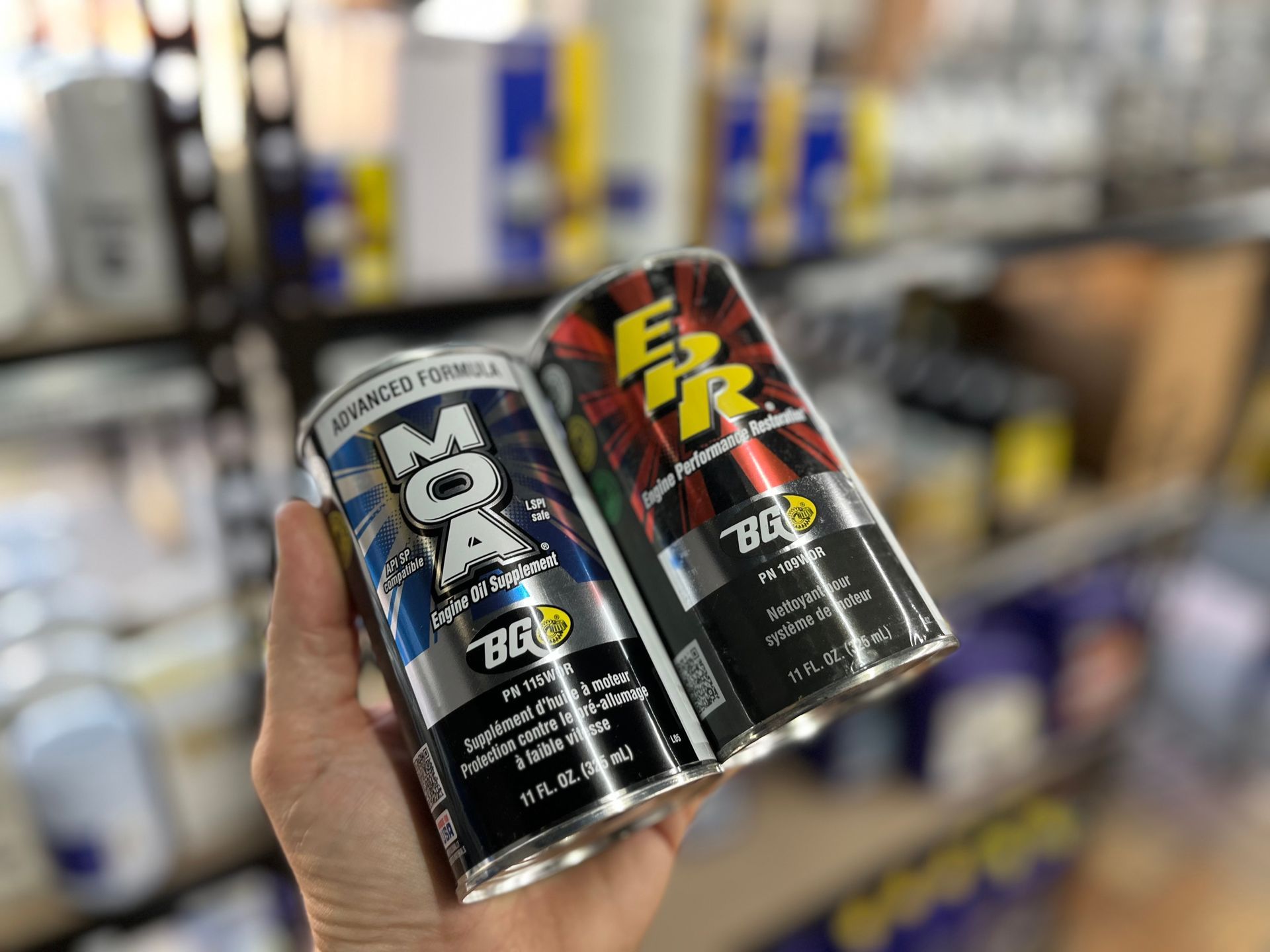 A person is holding two cans of engine oil in their hand | Fast Lane Auto Repair