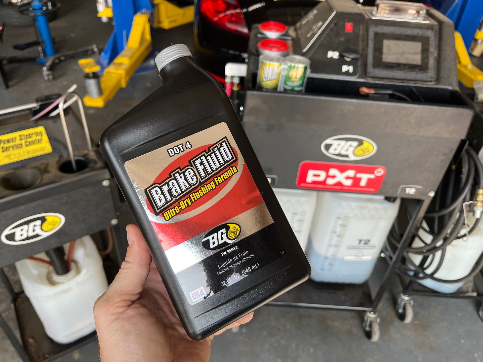 A person is holding a bottle of brake fluid | Fast Lane Auto Repair