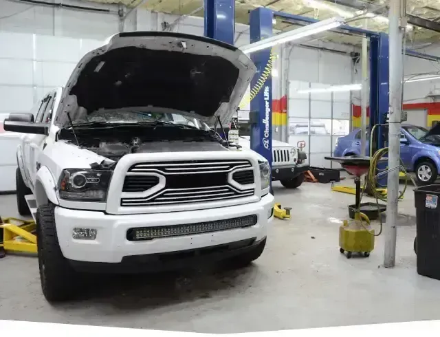 White truck in garage with hood up | Fast Lane Auto Repair