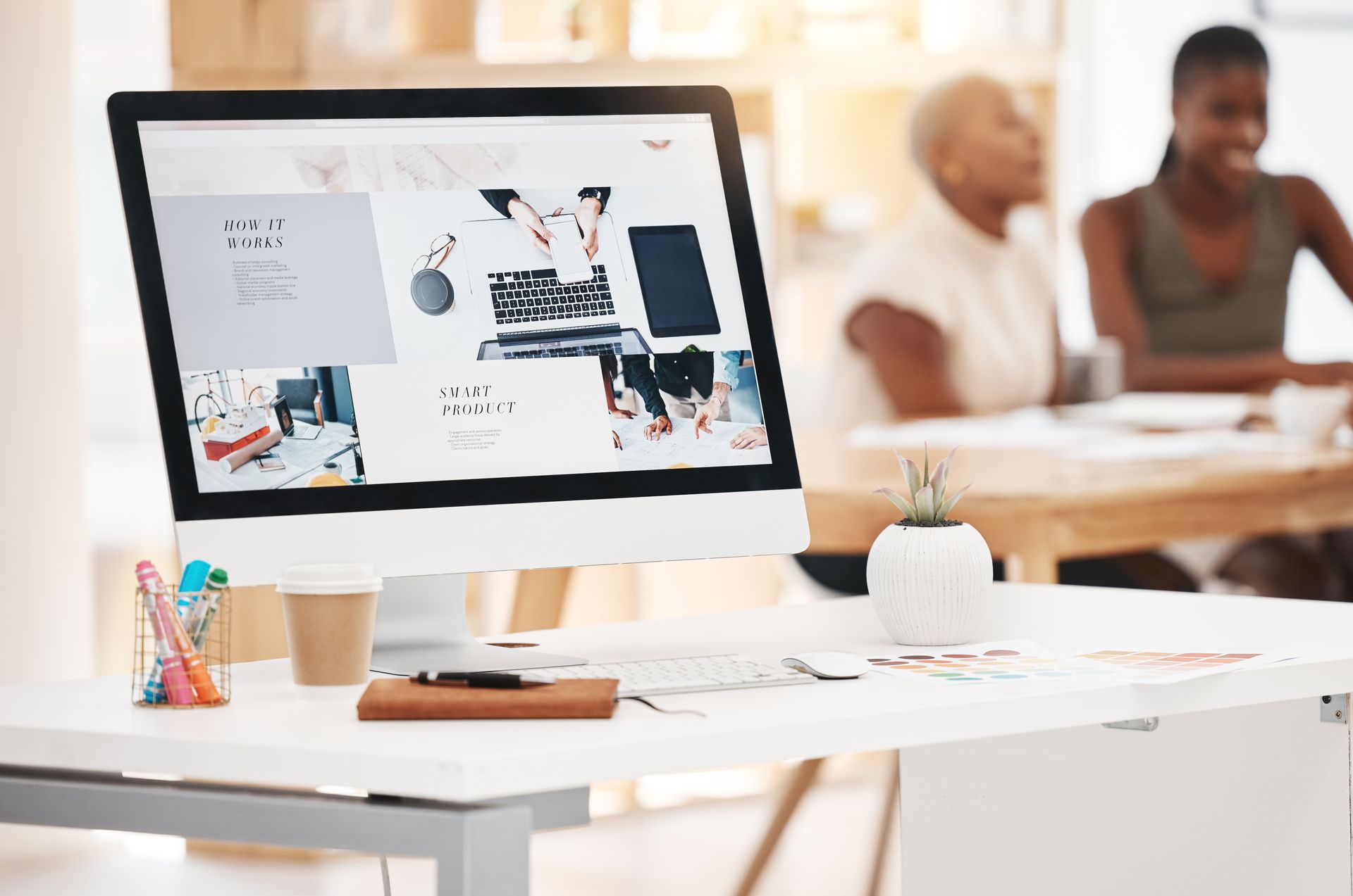 A computer monitor is sitting on a desk in an office.