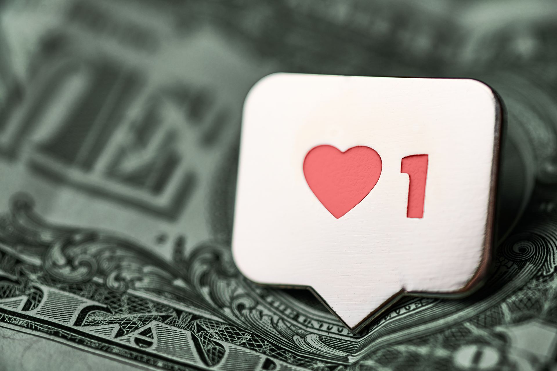 A heart with the number 1 on it is on a dollar bill.