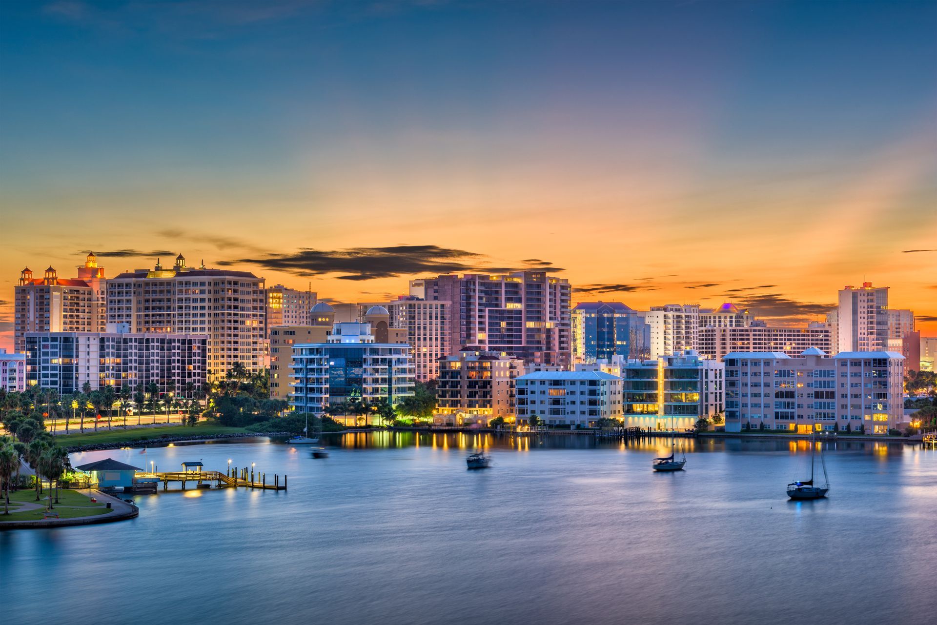 Sarasota - A city skyline overlooking a body of water at sunset.