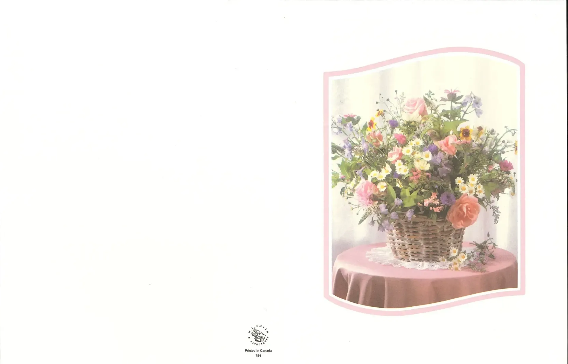 Basket of colorful flowers on a table, soft pink and white backdrop.