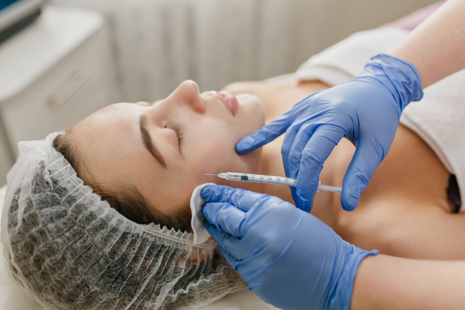 A woman is getting a botox injection in her face.