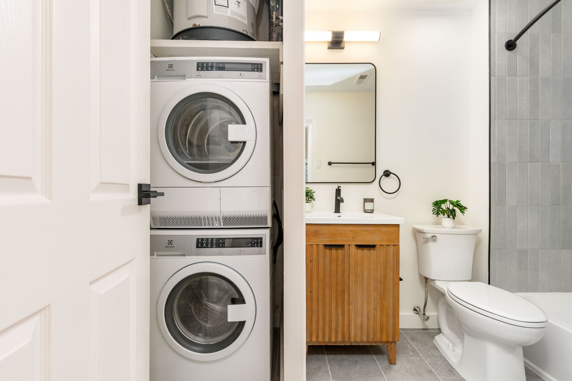A bathroom with a washer and dryer stacked on top of each other.
