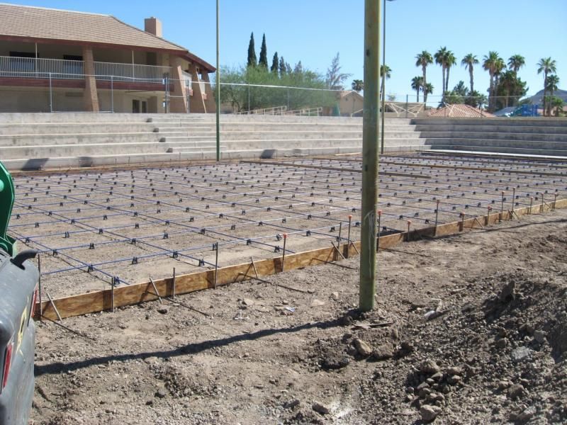 A truck is parked in the dirt in front of a building