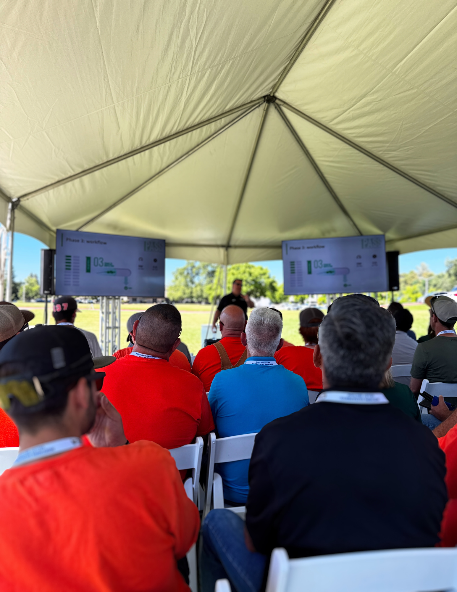 A man is holding a microphone in front of a crowd of people