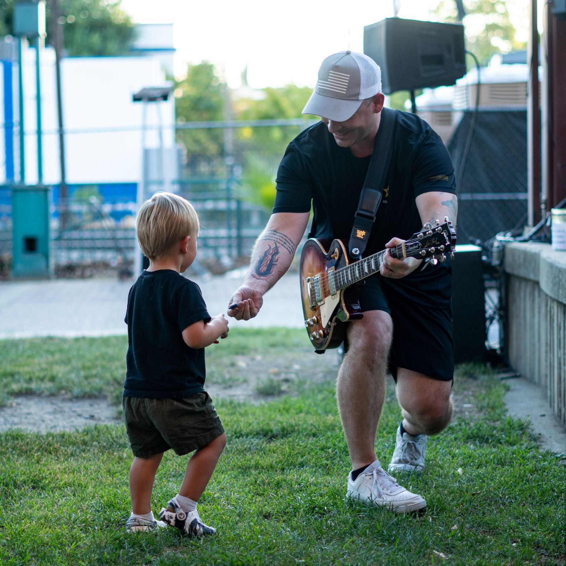 A man wearing sunglasses and a baseball cap is playing drums